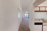 Located at 6710 Collins Road in Jacksonville, FL, this two-story, 3-bedroom, 2-bathroom home offers a well-organized layout spread across two levels. The main floor encompasses the majority of the living space, featuring a combined dining and living area with striking vaulted ceilings, a ceiling fan with light fixture, and plush carpeting throughout. A sliding glass door in the living room floods the space with natural light and opens to a private balcony with outdoor views. The adjacent kitchen is efficiently designed in a U-shape layout, featuring white cabinetry with wood trim accents, laminate countertops, a double sink, dishwasher, electric range, and refrigerator, all set on light wood-style flooring. Three carpeted bedrooms each include ceiling fans and closet space, providing comfortable and functional retreats. The bathrooms are clean and practical, with one featuring a full tub-shower combination lined with classic white subway tile and wood-style flooring. Additional highlights include multiple closets throughout, a dedicated laundry area, utility room, and staircase access to the upper level. The overall ambiance is bright and neutral, offering a move-in ready canvas.