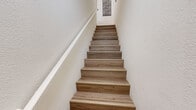 Located in San Marcos, CA, this two-story, 2-bedroom, 3-bathroom home offers a well-designed layout with light wood flooring flowing throughout. The main living area is an open-concept space combining the living room, dining room, and kitchen. The living room is bathed in natural light from multiple windows dressed with white blinds and features a tile-surround fireplace, crown molding, and space for comfortable seating. The dining area accommodates a full-size table and is accented by a pendant light fixture and crown molding. The kitchen is equipped with warm wood cabinetry, granite countertops, a breakfast bar, and pendant lighting. The bedrooms are well-proportioned, with the primary bedroom offering French doors that open to a private balcony, delivering outdoor views and additional natural light. The bathrooms are clean and functional — one features a glass-enclosed shower, while another offers a full tub and shower combination with a granite-topped vanity and rich wood cabinetry. A versatile additional room with large windows and built-in shelving provides flexible use as a home office or study. Two staircases connect the levels, adding convenience to the thoughtful floor plan.