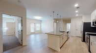 Located at 659 Treeland Dr in Ladson, South Carolina, this single-story residence offers a clean, modern design throughout. The open-concept layout connects the kitchen and living area seamlessly, creating a spacious and airy atmosphere enhanced by light wood-style flooring and neutral wall tones.

The kitchen is a standout feature, centered around a large island with a granite countertop and an integrated sink, illuminated by a trio of pendant lights overhead. White cabinetry extends to the upper walls, complemented by a subway tile backsplash and a full suite of stainless steel appliances, including a refrigerator, range, microwave, and dishwasher. Recessed lighting adds a polished, well-lit ambiance to the space.

The living area receives natural light through double doors fitted with blinds. Bedrooms are carpeted for comfort, each equipped with a ceiling fan and window, with closet access nearby. The bathrooms are finished consistently with granite-topped vanities, light wood-toned cabinetry, large mirrors, and tile-style flooring. A dedicated laundry room provides added convenience with a full-size washer and dryer included.