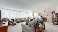 Located at 4801 N Hills Blvd in North Little Rock, Arkansas, this single-floor residence offers a thoughtfully designed layout with generous living spaces and standout views of the surrounding landscape. The open living area is a highlight of the home, featuring floor-to-ceiling vertical blinds that frame sweeping panoramic views and flood the space with natural light. Crown molding, textured ceilings, and soft carpeting throughout lend a classic, comfortable ambiance. The living room flows naturally into a dining area, where a ceiling fan and large sliding glass door open to a balcony overlooking an expansive cityscape. The kitchen is well-equipped, showcasing rich wood cabinetry, light granite countertops, light hardwood-style flooring, and a full suite of appliances including a stainless steel refrigerator and gas range. The bedrooms are calm and restful, each with plush carpeting, ceiling fans, and vertical blinds providing privacy while allowing natural light. The bathrooms feature granite-topped vanities and light tile flooring, offering a clean, updated aesthetic. Throughout the residence, the interplay of natural light, open sight lines, and elevated views creates an inviting and functional living environment.