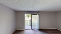 Located at 3219 N Talbot Ave in Erlanger, Kentucky, this single-floor unit offers a practical and straightforward layout suitable for comfortable everyday living. The entry area transitions between hard-surface wood-look flooring and carpeted spaces, creating a clear distinction between functional and living zones.

The kitchen is well-equipped with warm oak cabinetry providing ample upper and lower storage, light countertops, a double-basin sink, a black electric range, a dishwasher, and a refrigerator. A textured ceiling and flush-mount lighting complete the space. Adjacent to the kitchen, the main living area features wood-look flooring and neutral gray walls, with a sliding glass door that opens onto a private balcony overlooking a greenery-filled outdoor setting, allowing natural light to fill the room.

The bedrooms are carpeted and finished with neutral tones, each featuring textured ceilings and closet space with wood-panel sliding or hinged doors. The bathroom includes tile flooring, a full tub-shower combination with surround, a toilet, and a wood-vanity with a light countertop. Throughout the unit, consistent neutral wall colors, white trim, and textured ceilings contribute to a clean, cohesive aesthetic.
