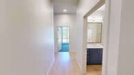 Located at 355 E 5th Ave in Eugene, Oregon, this thoughtfully designed single-floor residence offers three bedrooms and two bathrooms with a clean, contemporary aesthetic. The open-concept kitchen and living area immediately impresses with dramatically high ceilings and expansive floor-to-ceiling windows that flood the space with natural light and offer views of the surrounding neighborhood. The kitchen is a standout, featuring bold navy-blue cabinetry paired with light wood upper cabinets, a speckled quartz waterfall island with an undermount sink, stainless steel appliances, and a tiled backsplash. Pendant lighting above the island adds a modern finishing touch. The living area extends to an exterior door that opens to an outdoor space framed by exposed brick. Light hardwood flooring flows throughout the main areas, creating a warm and cohesive feel. The bedrooms offer a comfortable scale, with some featuring plush carpeting and generous windows. The primary bedroom includes access to a well-organized walk-in closet with adjustable wire shelving. Both bathrooms are finished with the same speckled quartz countertops, navy vanity cabinetry, framed mirrors, and a sleek glass-enclosed walk-in shower, maintaining design consistency across the home.