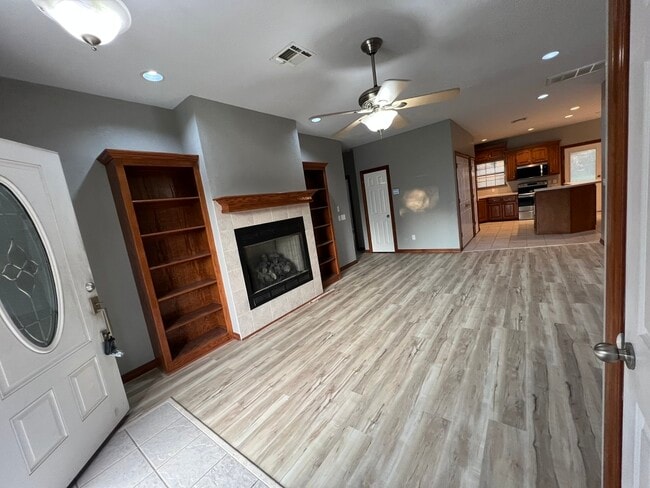 living room with 2 book cases and fireplace in between with ceiling fan - 1000 Gale