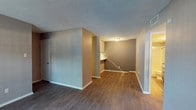 Located at 4625 71st St in Lubbock, Texas, this single-floor unit offers a well-organized layout with a variety of thoughtful finishes throughout. The living area is a welcoming, open space featuring rich hardwood-style flooring, neutral-toned walls, and a textured ceiling. A tiled fireplace with a sleek surround serves as a focal point, complemented by a large sliding glass door fitted with vertical blinds that allows natural light to pour in and provides access to an outdoor area. A built-in desk nook adds a practical touch to the living and dining area. The galley-style kitchen is efficiently designed with dark cabinetry lining both sides, light countertops, a double-basin stainless steel sink, and black appliances including a range and refrigerator. Track lighting overhead adds both function and style to this space. The bathroom is well-appointed with a tiled tub-shower combination, a dark-framed vanity mirror, a single-basin sink set in a speckled countertop, and a textured ceiling with overhead lighting. The bedroom features plush carpeting, a closet, and a window with blinds that brings in natural daylight. Clean white baseboards and consistent neutral tones throughout the unit create a cohesive and comfortable living environment.