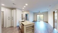 Located at 900 E Six Forks Rd in Raleigh, NC, this 2-bedroom, 2-bathroom residence offers a well-designed, single-level layout with modern finishes throughout. The open-concept living and kitchen area serves as the heart of the home, anchored by a central island with a built-in sink, light countertops, open shelving, and a matte black faucet. White shaker-style cabinetry lines the kitchen walls, complemented by a blue tile backsplash and a full suite of stainless steel appliances, including a refrigerator, range, and microwave. Recessed lighting illuminates the space, which flows seamlessly into the living area. The living room features wood-look plank flooring, a ceiling fan, and a sliding glass door that opens to a private balcony with outdoor views. Both bedrooms are carpeted and include closets, offering comfortable and functional retreats. The primary bedroom is generously sized with an en-suite bathroom featuring a vanity with ample cabinetry. The second bathroom includes a full soaking tub and shower combination. A dedicated laundry area adds everyday convenience. Throughout, neutral tones and clean lines create a bright, welcoming ambiance.