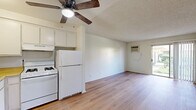 Located at 44221 Kingtree Ave in Lancaster, CA, this ground-floor unit offers a practical, efficiently designed single-story layout with one bedroom and one bathroom. Throughout the unit, warm-toned laminate flooring provides a cohesive, clean aesthetic that contrasts nicely with the white walls and textured ceilings.

The living area is the largest zone in the unit, featuring a wall-mounted air conditioning unit and a sliding glass door that fills the space with natural light and provides direct outdoor access with views of surrounding greenery. The open layout connects seamlessly to a compact kitchen equipped with white cabinetry, a ceiling fan overhead, and essential appliances.

The bedroom offers a comfortable, functional space with a standard sliding-door closet for storage and a window fitted with horizontal blinds that allows natural light while maintaining privacy. The room's neutral walls and laminate flooring maintain consistency with the rest of the unit.

The bathroom features light wood-look flooring, a white vanity with under-cabinet storage, a wall-mounted mirror with overhead lighting, and a full tub-shower combination with a curtain rod. The clean, white finishes throughout the bathroom contribute to a bright, functional feel. Overall, the unit presents a straightforward, move-in-ready living space.
