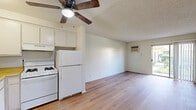 Located at 44221 Kingtree Ave in Lancaster, CA, this ground-floor unit offers a practical, efficiently designed single-story layout with one bedroom and one bathroom. Throughout the unit, warm-toned laminate flooring provides a cohesive, clean aesthetic that contrasts nicely with the white walls and textured ceilings.

The living area is the largest zone in the unit, featuring a wall-mounted air conditioning unit and a sliding glass door that fills the space with natural light and provides direct outdoor access with views of surrounding greenery. The open layout connects seamlessly to a compact kitchen equipped with white cabinetry, a ceiling fan overhead, and essential appliances.

The bedroom offers a comfortable, functional space with a standard sliding-door closet for storage and a window fitted with horizontal blinds that allows natural light while maintaining privacy. The room's neutral walls and laminate flooring maintain consistency with the rest of the unit.

The bathroom features light wood-look flooring, a white vanity with under-cabinet storage, a wall-mounted mirror with overhead lighting, and a full tub-shower combination with a curtain rod. The clean, white finishes throughout the bathroom contribute to a bright, functional feel. Overall, the unit presents a straightforward, move-in-ready living space.