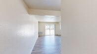 Located at 1066 Sunnyvale Saratoga Rd in Sunnyvale, CA, this single-floor unit offers an efficient and well-organized layout that maximizes every square foot. The combined kitchen and living area forms the heart of the space, where light wood-style flooring runs throughout, creating a clean and cohesive aesthetic. The kitchen is equipped with white appliances, including an electric range and refrigerator, complemented by two-tone cabinetry featuring white lower cabinets with dark wood accents above. Granite-style countertops and an under-cabinet range hood complete the functional cooking space. The living area is bright and open, with neutral warm-toned walls, a textured ceiling, and a wall-mounted HVAC unit. A sliding glass door at the far end of the living room floods the space with natural light and provides direct access to a private balcony with outdoor views, enhancing the sense of openness. The bathroom is thoughtfully finished with dark tile flooring, a granite-top vanity, and a tub-shower combination enclosed by sliding glass doors and framed with classic white subway tile. The overall ambiance is clean, modern, and move-in ready, ideal for those seeking a practical residence in the heart of Silicon Valley.