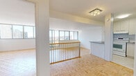 Located on Avenue Atwater in the heart of Montréal, this well-appointed one-bedroom, one-bathroom unit offers a bright and functional layout with consistent parquet flooring throughout. The combined kitchen and living area forms the heart of the unit, where large floor-to-ceiling windows flood the space with natural light and frame impressive views of the Montréal skyline and surrounding cityscape. The living area features a railing-accented open section that enhances the sense of openness, complemented by a modern flush-mount ceiling fixture. The kitchen is efficiently designed with light wood cabinetry, a neutral countertop, a tiled backsplash, and full-sized appliances including a refrigerator and dishwasher, all set on clean tile flooring. The bedroom is a well-sized, serene retreat with expansive windows offering panoramic city views, parquet flooring, and a built-in closet with double doors for ample storage. The bathroom is clean and contemporary, featuring a tiled tub-shower combination, a vanity with storage cabinetry, and a mirrored medicine cabinet. Throughout the unit, the white walls, abundant natural light, and warm wood-toned floors create a cohesive, inviting atmosphere.