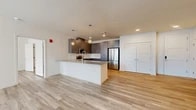 Located at 7501 Jefferson St in Albuquerque, New Mexico, this thoughtfully designed 2-bedroom, 2-bathroom residence offers a seamless blend of modern aesthetics and practical living. The open-concept kitchen and living area forms the heart of the home, showcasing light wood-tone flooring that flows throughout the entire space. The kitchen is appointed with sleek gray cabinetry extending to the ceiling, a white subway tile backsplash, stainless steel appliances including a refrigerator, range, and microwave, and a large central island with a quartz-style countertop and pendant globe lighting above — ideal for both meal preparation and casual dining.

The spacious living area receives ample natural light and connects effortlessly to the kitchen, creating an inviting and airy atmosphere. Both bedrooms are well-proportioned, featuring neutral tones, wood-style flooring, ceiling fans, and windows offering views of the surrounding Albuquerque skyline. Three closets, including a generous walk-in with wire shelving, provide abundant storage throughout.

The bathrooms are finished with gray vanities, quartz countertops, large-format tile surrounds, and soaking tub-shower combinations. Additional conveniences include a dedicated laundry area, a hallway connecting the private quarters, and a balcony perfect for enjoying the New Mexico outdoors.