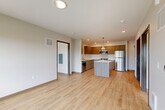 Located at 695 Peterson Rd in Burlington, WA, this thoughtfully designed 2-bedroom, 2-bathroom unit offers a clean, modern aesthetic throughout. Light wood-tone flooring flows seamlessly across the open-concept living and kitchen area, creating a bright and cohesive feel. The contemporary kitchen is a standout feature, equipped with stainless steel appliances including a refrigerator, range, and microwave, complemented by warm wood-grain cabinetry, crisp white countertops, and a central island with pendant lighting — ideal for both cooking and casual dining. Recessed lighting throughout the main living area adds to the polished, modern atmosphere. Both bedrooms are well-proportioned and filled with natural light from large windows that frame views of the surrounding Burlington neighborhood and lush greenery. The primary bedroom offers a comfortable and spacious retreat. The two bathrooms maintain the unit's clean design language, featuring wood-tone vanities, light flooring, a soaking tub in one bath, and a glass-enclosed walk-in shower in the other. A stacked in-unit washer and dryer adds everyday convenience. With neutral tones, modern finishes, and a practical layout, this unit delivers a refined living experience in a well-connected Washington State community.