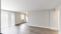 Located at 275 E High St in Glassboro, NJ, this two-bedroom, one-bathroom residence offers a well-organized layout across a single floor. The open living area greets you with durable hardwood-style flooring, neutral gray walls, and vertical blinds framing a sliding glass door that invites natural light throughout the space. A staircase with a classic iron railing adds a functional architectural detail to the living area.

The kitchen is a standout feature, finished with rich dark-brown cabinetry, white countertops, and a full suite of stainless steel appliances including a refrigerator, gas range, microwave, and dishwasher. Light tile flooring and a window with blinds complete the functional and stylish space.

Both bedrooms are carpeted for comfort and finished in soft neutral tones. The primary bedroom is generously sized, offering ample wall space and multiple windows that fill the room with natural light. The second bedroom is equally well-lit, with two windows and baseboard heating.

The bathroom features a clean, white aesthetic with tile flooring, a full bathtub and shower combination, a white vanity, and a decorative mosaic tile accent border, adding a touch of character to the otherwise crisp design. A connecting hallway ties all rooms together seamlessly.