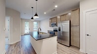 Located at 80 S. Sounders Ave in Columbus, OH, this single-floor, 1-bedroom, 1-bathroom residence offers a thoughtfully designed open-concept layout that seamlessly connects the kitchen, dining, and living areas. The kitchen is a standout feature, showcasing a large center island with a dark granite countertop, an undermount sink with a matte black faucet, and stylish pendant lighting overhead. Light wood cabinetry extends to the ceiling for ample storage, while a full suite of stainless steel appliances — including a French door refrigerator, electric range, and built-in microwave — completes the space. Light wood-look flooring runs throughout the main living areas, contributing to a bright, airy ambiance enhanced by natural light from multiple windows. The bedroom offers plush carpeting, two windows with outdoor views, and access to a dedicated closet. The bathroom features a wood-tone vanity with a granite countertop, an undermount sink, matte black hardware, and a large mirror. Additional conveniences include an in-unit laundry area and a private patio with a pergola-style covering, ideal for outdoor relaxation. Clean white walls and modern shaker-style interior doors complete the refined, contemporary aesthetic throughout.