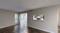 Located at 500 Maxham Rd in Austell, Georgia, this one-bedroom, one-bathroom unit offers a well-organized single-floor layout designed for efficient living. Rich, dark hardwood-style flooring runs throughout the main living areas, complemented by neutral gray walls and clean white trim that create a modern, cohesive aesthetic.

The open living and dining areas are bathed in natural light from multiple windows fitted with horizontal blinds, offering views of surrounding greenery. A distinctive pass-through window connects the living area to the kitchen, enhancing the sense of openness. The kitchen features dark cabinetry, a tile backsplash with a geometric pattern, and black appliances including a range and refrigerator, all set beneath a textured ceiling.

The bedroom is a comfortable size, finished with plush carpeting, and includes a closet with additional natural light provided by a dual-pane window overlooking outdoor foliage. The bathroom is equipped with a full soaking tub and shower combination, accented by white subway tile surround and chrome fixtures.

A hallway connects the main rooms, and the unit includes a dedicated closet for additional storage. The overall layout is practical and well-proportioned, making it a functional and inviting living space.