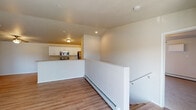 This single-floor residence offers a clean, functional layout with a neutral color palette and quality finishes throughout. The open-concept living area features smooth hardwood-style flooring, a ceiling fan, and a sliding glass door that floods the space with natural light and opens to a private balcony. A half-wall partition neatly separates the living area from the kitchen, which is designed in a galley style with white shaker cabinetry, granite-look countertops, stainless steel appliances including a refrigerator, range, and built-in microwave, and a double stainless steel sink. The bedrooms are carpeted and generously sized, each equipped with ceiling fans and ample closet space, including a large double-door closet in one room. The unit includes two full bathrooms: one featuring a vanity with granite-look countertops, a tub-shower combination with a curved curtain rod, and overhead cabinetry; the second offering a walk-in shower stall, matching vanity, and wood-look flooring. Baseboard heating is present throughout the living spaces. The overall aesthetic is bright, clean, and move-in ready, with consistent finishes that lend a cohesive feel to the entire unit.