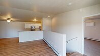This single-floor residence offers a clean, functional layout with a neutral color palette and quality finishes throughout. The open-concept living area features smooth hardwood-style flooring, a ceiling fan, and a sliding glass door that floods the space with natural light and opens to a private balcony. A half-wall partition neatly separates the living area from the kitchen, which is designed in a galley style with white shaker cabinetry, granite-look countertops, stainless steel appliances including a refrigerator, range, and built-in microwave, and a double stainless steel sink. The bedrooms are carpeted and generously sized, each equipped with ceiling fans and ample closet space, including a large double-door closet in one room. The unit includes two full bathrooms: one featuring a vanity with granite-look countertops, a tub-shower combination with a curved curtain rod, and overhead cabinetry; the second offering a walk-in shower stall, matching vanity, and wood-look flooring. Baseboard heating is present throughout the living spaces. The overall aesthetic is bright, clean, and move-in ready, with consistent finishes that lend a cohesive feel to the entire unit.