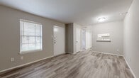 Located at 1541 Moritz Dr in Houston, Texas, this single-floor unit offers a clean, modern aesthetic defined by neutral warm-gray walls and durable wood-look vinyl plank flooring that runs consistently throughout the space. The open living area greets residents upon entry, bathed in natural light from a large window fitted with horizontal blinds. The layout flows intuitively, with a hallway connecting the main living space to the private rooms beyond.

The kitchen is designed for functionality, featuring white cabinetry lining both sides of a galley-style layout, complete with a stainless steel sink, electric range and oven, a full-size refrigerator, and a dishwasher — all in matching white appliances. A pass-through counter connects the kitchen to the main living area, enhancing the sense of openness.

The bedrooms are generously proportioned, offering ample wall space and natural light through blinded windows. One bedroom includes a ceiling fan with integrated lighting, adding comfort and practicality. The bathroom is outfitted with a wide vanity topped with a light stone-pattern countertop, white cabinetry below, a large mirror, and stylish overhead lighting. The textured ceiling adds a subtle architectural detail consistent throughout the unit. Overall, the space presents a fresh, move-in-ready environment with a cohesive and understated design.