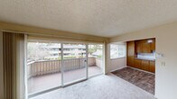 This single-floor unit offers a well-organized layout that balances comfort and functionality. The living area is bright and inviting, featuring plush carpeting and large sliding glass doors that open onto a private balcony, flooding the space with natural light and providing views of the surrounding greenery and neighboring buildings. A secondary window further enhances the airy feel of the room. The transition from the living area to the kitchen is marked by a shift to wood-look hard flooring, creating a practical and easy-to-maintain surface underfoot. The kitchen is equipped with warm wood-toned cabinetry, granite-look countertops, a stainless steel sink, and a stainless steel electric range. A white subway tile backsplash adds a clean, classic touch, while recessed lighting ensures the workspace is well-lit. The bedroom is a comfortable retreat, finished with soft carpeting, a window with blinds for natural light and privacy, and a built-in closet with a hanging rod for ample storage. The bathroom features a full tub and shower combo with tile surround, a window for ventilation, wood-look flooring, and a vanity with granite-look countertop. The textured ceilings are consistent throughout the unit, adding a classic residential character to the overall space.