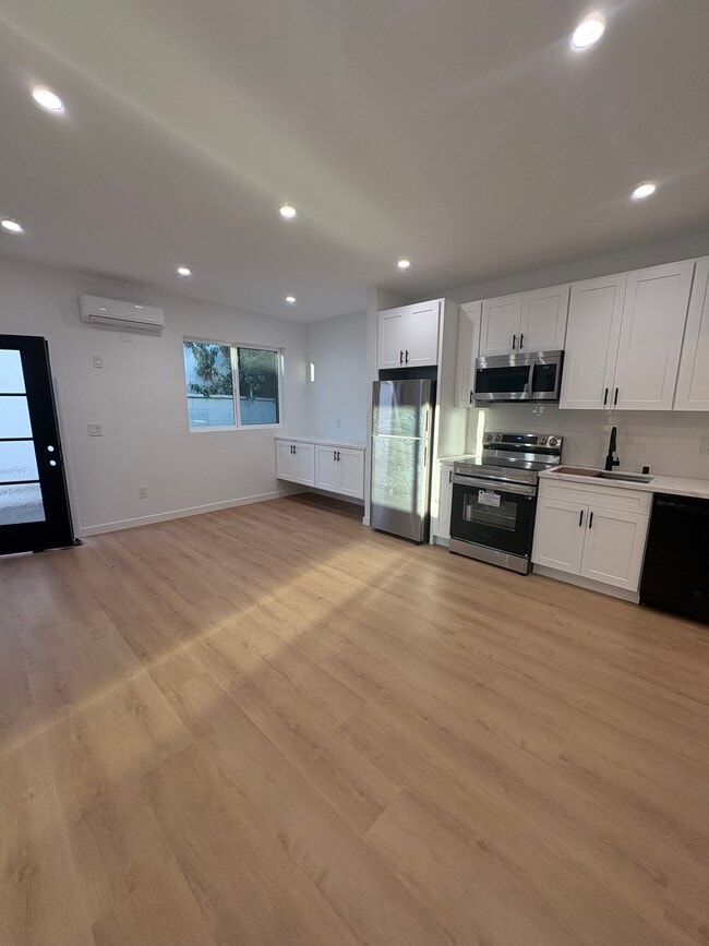 Open concept living room, dining room, and kitchen with brand new appliances. - 7834 S Harvard Blvd