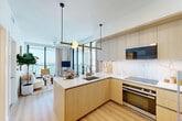 Located along Biscayne Boulevard in Miami's vibrant Edgewater neighborhood, this well-appointed 2-bedroom, 2-bathroom residence offers a thoughtfully designed open-concept layout with contemporary finishes throughout. Light oak hardwood flooring flows seamlessly from the welcoming hallway — adorned with curated artwork — into the living and kitchen areas, creating a warm, cohesive aesthetic.

The kitchen is a standout feature, showcasing flat-panel light wood cabinetry, a striking marble-tile backsplash, white quartz countertops, a central island with an undermount sink, and stainless steel appliances, all illuminated by modern globe pendant lighting. The kitchen opens directly to the living room, which benefits from floor-to-ceiling glass doors leading to a spacious private balcony with sweeping panoramic views of the Miami skyline and Biscayne Bay.

Each bedroom is bright and serene, with the primary suite offering direct balcony access, a dedicated closet, and an en-suite bathroom featuring a glass-enclosed walk-in shower with large-format marble-look tiles and brushed gold fixtures. A second bedroom, additional full bathroom, laundry area, and utility room complete this well-rounded residence, making it an ideal urban retreat in the heart of Miami.