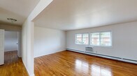 Located at 272 Ward Ave in Bordentown, NJ, this 2-bedroom, 1-bathroom unit offers a practical and well-maintained single-floor layout. Warm hardwood flooring extends consistently throughout the main living areas and bedrooms, providing a cohesive and inviting aesthetic. The living room is generously sized, bathed in natural light through large windows that offer outdoor views, and features baseboard heating alongside a wall-mounted air conditioning unit for year-round comfort. The kitchen is a standout space, outfitted with rich dark wood cabinetry, granite-style countertops, a classic subway tile backsplash, and a full suite of stainless steel appliances including a refrigerator, range, microwave, and dishwasher. Light tile flooring grounds the kitchen area distinctly from the rest of the unit. The primary bedroom is spacious, featuring a closet, a window for natural light, and its own wall AC unit. The second bedroom is equally bright and well-proportioned. The bathroom is finished with a granite-topped dark wood vanity, subway tile shower surround, and light tile flooring. A hallway and closet round out the layout, contributing to the unit's efficient and comfortable design.