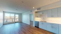 Located at 20060 Prairie St in the Chatsworth neighborhood of Los Angeles, this modern single-floor unit offers a thoughtfully designed open-concept layout filled with natural light. Warm hardwood flooring flows throughout the living areas and bedrooms, complementing the clean, contemporary aesthetic.

The kitchen is a standout feature, outfitted with light blue shaker-style cabinetry with vertical beadboard detailing, stainless steel appliances including a French door refrigerator, electric range, and built-in microwave, as well as a double-basin sink and a dishwasher. Crisp white countertops and under-cabinet lighting complete the polished look. The open living area is bathed in natural light from large double French doors, which offer views of the surrounding neighborhood.

The bedrooms are generously sized with hardwood floors, large windows framing scenic outdoor views, and access to a walk-in closet. The bathrooms are finished with hexagonal tile flooring, light blue beadboard vanities with white quartz countertops, illuminated mirrors with integrated side lighting, and a full soaking tub with subway tile surround in one bathroom. The overall ambiance is bright, clean, and move-in ready, reflecting a modern California aesthetic throughout.