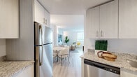 This well-designed one-bedroom, one-bathroom unit in Miami, FL offers a thoughtfully arranged floor plan that maximizes every inch of its compact footprint. Light wood-look flooring flows throughout, creating a warm and cohesive aesthetic across all rooms.

The living room is bright and airy, featuring a large window that fills the space with natural light. Clean white walls serve as a backdrop for bold wall art, while the open layout accommodates comfortable seating and a relaxed yet stylish atmosphere.

Adjacent to the living area, the dining space features wall sconce lighting and a round marble-top table with modern upholstered chairs, complemented by a coastal-themed artwork that nods to Miami's surroundings.

The kitchen is outfitted with white cabinetry, granite countertops, and stainless steel appliances including an electric range and microwave. A peninsula counter provides added prep space and a natural transition into the dining area.

The bedroom is a serene retreat with a ceiling fan, a spacious closet, and windows that invite natural light. Neutral tones and curated wall art contribute to a calm and restful environment.

The bathroom is clean and modern, featuring a granite-topped vanity with gray cabinetry, wood-look tile flooring, a large mirror, and a walk-in shower, all finished in a crisp white palette.