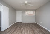 Located in Harvey, Louisiana, this single-story home offers a practical and well-maintained layout with consistent wood-look flooring flowing throughout every room. The open living area is anchored by a ceiling fan and connects seamlessly to the kitchen, creating an efficient and comfortable flow. Natural light enters through multiple windows fitted with blinds, brightening the neutral gray walls and textured popcorn ceilings found across the home.

The kitchen is equipped with tan cabinetry offering generous storage, a double sink, a decorative tile backsplash, and a suite of black appliances including an electric range, dishwasher, and refrigerator. Adjacent to the kitchen is a dedicated laundry area with washer and dryer hookups.

The bedrooms are well-proportioned, each featuring wood-look flooring, neutral walls, and multiple windows that allow for ample natural light. The primary bedroom includes two closets, providing notable storage capacity. Additional bedrooms also offer closet space and comfortable dimensions.

The full bathroom features white tile extending from floor to tub surround, a combination tub and shower, and wood-look flooring that complements the rest of the home. Clean white fixtures and a window complete this functional space. Overall, the home presents a clean, move-in-ready interior throughout.