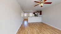 Located in Clarksville, TN, this two-story home offers a practical and comfortable layout across two well-defined levels. The main floor opens into a bright, open-concept living room and kitchen area finished with warm hardwood-style flooring and recessed lighting. The kitchen features rich dark cabinetry, granite-style countertops, a peninsula with bar seating, and stainless steel appliances, while a ceiling fan with light kit adds comfort to the living space. Natural light flows in through front-facing windows, and a paneled entry door with window provides an inviting entrance. The main level also includes a utility room and an attached garage with a two-panel sectional door, offering ample storage and vehicle parking. Upstairs, the two bedrooms are carpeted for warmth and comfort, each equipped with ceiling fans and windows that bring in natural light. The primary bedroom is generously sized and includes a walk-in closet with wire shelving. A full shared bathroom on the upper level is finished with stone-look tile flooring and includes a combined tub and shower, a vanity with an undermount sink, and brushed nickel fixtures. Three closets throughout the home provide excellent storage throughout.