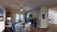 This single-story, two-bedroom, two-bathroom residence in Conroe, Texas offers a thoughtfully designed layout that balances comfort and style. Wood-style flooring flows throughout the main living areas, providing warmth and visual continuity across the open-concept space.

The living room serves as the heart of the home, featuring a ceiling fan, neutral walls accented by a bold gray feature wall, and a sliding glass door that admits natural light and outdoor views. The kitchen is outfitted with dark espresso cabinetry, granite-style countertops, a mosaic tile backsplash, and black appliances, including a refrigerator and range. A peninsula with a stainless steel sink connects the kitchen to an adjacent dining area, making it well-suited for everyday living and entertaining.

Both bedrooms are carpeted and include ceiling fans and ample closet space. The primary bedroom features a walk-in closet, while both bathrooms are finished with dark cabinetry, granite-style countertops, wood-style flooring, and tiled tub-shower combinations. The overall ambiance is modern yet approachable, with consistent finishes throughout that create a cohesive and inviting living environment.