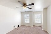 Located at 6921 W Gore Blvd in Lawton, Oklahoma, this 2-bedroom, 1-bathroom home is thoughtfully arranged across three floors, offering a practical and efficient layout. The main living level features a galley-style kitchen equipped with white cabinetry, light countertops, a stainless steel refrigerator, an electric range, a dishwasher, and a matte black faucet over a double sink — all complemented by wood-look luxury vinyl flooring. An adjacent dining area shares the same flooring, creating a cohesive open feel. A dedicated laundry space and hallway add further convenience to the layout. The upper floor hosts both bedrooms, each carpeted for comfort. The spacious primary bedroom features dual windows with blinds and a ceiling fan, filling the room with natural light and airflow. The second bedroom also includes a window and access to a closet with built-in shelving. The full bathroom is finished in a clean, all-white palette, featuring a tub/shower combo, a vanity with under-sink storage, a medicine cabinet, and wood-look flooring. Neutral tones, white trim, and panel-style doors are consistent throughout, giving the home a clean, move-in-ready aesthetic.