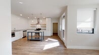 Located at 1211 East 7th Street in Tulsa, Oklahoma, this single-story home blends modern design with farmhouse-inspired details to create a clean, contemporary living environment. The open-concept layout connects the main living area to a well-appointed kitchen, where shiplap accent walls serve as a striking backdrop for white cabinetry, granite countertops, and warm natural wood floating shelves. A freestanding metal-framed island with a granite top anchors the kitchen, complemented by stainless steel appliances including a side-by-side refrigerator, range with a wall-mounted range hood, built-in microwave, and dishwasher. Pendant lighting adds a refined touch above the island and kitchen workspace. Light-toned hardwood-style flooring runs consistently throughout the home, enhancing the bright, airy atmosphere created by abundant natural light streaming through multiple windows. The bedroom is a comfortable, sun-filled retreat featuring a ceiling fan and generous closet access. The bathroom is finished with classic white subway tile in the tub-shower surround, hexagonal floor tile, a granite-topped vanity, and chrome fixtures, maintaining the home's cohesive aesthetic. The overall design emphasizes clean lines, quality materials, and a neutral palette that creates a welcoming, move-in ready space.