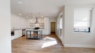 Located at 1211 East 7th Street in Tulsa, Oklahoma, this single-story home blends modern design with farmhouse-inspired details to create a clean, contemporary living environment. The open-concept layout connects the main living area to a well-appointed kitchen, where shiplap accent walls serve as a striking backdrop for white cabinetry, granite countertops, and warm natural wood floating shelves. A freestanding metal-framed island with a granite top anchors the kitchen, complemented by stainless steel appliances including a side-by-side refrigerator, range with a wall-mounted range hood, built-in microwave, and dishwasher. Pendant lighting adds a refined touch above the island and kitchen workspace. Light-toned hardwood-style flooring runs consistently throughout the home, enhancing the bright, airy atmosphere created by abundant natural light streaming through multiple windows. The bedroom is a comfortable, sun-filled retreat featuring a ceiling fan and generous closet access. The bathroom is finished with classic white subway tile in the tub-shower surround, hexagonal floor tile, a granite-topped vanity, and chrome fixtures, maintaining the home's cohesive aesthetic. The overall design emphasizes clean lines, quality materials, and a neutral palette that creates a welcoming, move-in ready space.