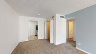 Located at 470 Maxey Rd in Houston, TX, this single-floor residence offers a straightforward and functional layout designed for comfortable everyday living. The open living area is finished with neutral wall-to-wall carpeting and crisp white walls, with a calming light blue accent wall adding a touch of color and character. Textured ceilings are consistent throughout the space, contributing to its classic interior style.

The galley-style kitchen is efficiently arranged with white cabinetry lining both sides, light wood-look flooring, a double sink, and appliances including a stove and refrigerator, making practical use of the available space. Adjacent areas connect smoothly to the living and sleeping quarters.

The bedrooms feature plush carpeting, white walls, and window blinds that allow for natural light while maintaining privacy. One bedroom is equipped with a ceiling fan, while closets with built-in hanging rods provide ample storage. The bathroom includes a single-sink vanity with white cabinetry, a wall-mounted mirror, overhead storage cabinets, a toilet, and a shower-tub combination, all finished with light wood-look flooring. The overall ambiance is clean, neutral, and move-in ready.