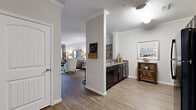 Located at 100 Heron Pointe Dr in Nashville, TN, this single-story, three-bedroom, two-bathroom home offers a well-appointed layout across a comfortable footprint. Crown molding and neutral gray tones are consistent throughout, lending a cohesive and polished aesthetic to every room.

The open-concept kitchen and living area serves as the heart of the home. The kitchen features dark espresso cabinetry, granite-style countertops, black appliances including a gas range, microwave, and refrigerator, and durable wood-look flooring. A defining architectural column visually separates the kitchen from the living room while maintaining an open feel. The living room is bright and inviting, with large windows dressed in floor-length drapes that allow ample natural light.

The dedicated dining room accommodates a round table for four and is accented by a pendant light fixture and crown molding, creating an intimate yet refined setting.

The spacious primary bedroom features plush carpeting, a ceiling fan, and a large window with outdoor views. A generous walk-in closet provides substantial storage. The secondary bedrooms are well-sized with soft carpeting. Both bathrooms include dark vanity cabinetry with stone-look countertops and tile flooring. A hallway connects the private sleeping quarters to the main living areas, completing this thoughtfully designed Nashville home.