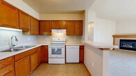 Located at 1405 N McCarthy Rd in Appleton, Wisconsin, this one-bedroom, one-bathroom unit offers a thoughtfully arranged single-floor layout with a comfortable sense of space throughout. The open-concept living, dining, and kitchen area serves as the heart of the home, anchored by a tile-surround fireplace with a wood mantel in the living room and accentuated by vaulted ceilings and a chandelier in the dining area. Natural light fills both spaces through well-placed windows. The kitchen is equipped with warm oak cabinetry, white appliances including a range, dishwasher, and refrigerator, light countertops, and tile flooring that extends into the bathroom. The spacious bedroom features vaulted ceilings, a ceiling fan, plush carpet, and a large walk-in closet with built-in shelving for ample storage — plus an additional closet nearby. The full bathroom includes an oak vanity, tile flooring, and convenient in-unit washer and dryer access tucked behind sliding doors. Additional highlights include multiple closets throughout, a hallway connecting key areas, and a private balcony. Baseboard heating is present throughout the unit, ensuring year-round comfort in the Wisconsin climate.