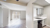Located at 1500 Magruder St in El Paso, Texas, this one-bedroom, one-bathroom unit offers a thoughtfully laid-out single-floor plan with a clean, neutral aesthetic throughout. Light wood-look flooring flows consistently across all main living areas, complementing the soft gray and white color palette on the walls and trim.

The living room is a bright, open space anchored by a sliding glass door dressed with vertical blinds, allowing generous natural light and outdoor views. A ceiling fan with integrated lighting adds both comfort and function to the room. The layout connects seamlessly to the kitchen via a half-wall pass-through, enhancing the open feel.

The galley-style kitchen is well-equipped, featuring gray cabinetry, white countertops, a stainless steel double sink, and a classic white subway tile backsplash. Black appliances, including a refrigerator, dishwasher, and range, provide a modern contrast to the light finishes.

The bedroom is a comfortable, sun-lit space with a ceiling fan, textured ceiling, and windows with blinds. It connects to a dedicated walk-in closet outfitted with built-in shelving and hanging rods for ample storage.

The bathroom includes a full tub-shower combination with chrome fixtures in a clean, white surround. Throughout the unit, textured ceilings and consistent flooring tie the design together into a cohesive, functional living space.