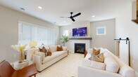 This well-designed two-story home combines contemporary style with functional living across a thoughtfully organized floor plan. The living room serves as a welcoming centerpiece, featuring a gas fireplace with a sleek wood mantle, recessed lighting, a ceiling fan, and generous natural light from multiple windows. Neutral tones and light flooring throughout create a cohesive, airy aesthetic.

The kitchen is a standout space, offering white shaker cabinetry with matte black hardware, a white quartz waterfall island with bar seating, subway tile backsplash, stainless steel appliances, and pendant lighting — all set over light hardwood-style flooring. A convenient mudroom entry with built-in cabinetry and matte black door hardware provides a practical transition space.

A dedicated home office features a sliding barn door and ample natural light, making it ideal for productivity. The primary bathroom is outfitted with a dual-sink vanity, white cabinetry, quartz countertops, and stylish pendant lighting. An expansive walk-in closet with wire shelving offers generous storage capacity.

The bedrooms are comfortably sized with plush carpeting and well-placed windows. An additional bedroom with soft carpet is perfectly suited for a child's room. The home's consistent use of neutral tones, matte black accents, and quality finishes throughout gives it a clean, modern character.