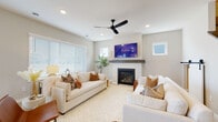 This well-designed two-story home combines contemporary style with functional living across a thoughtfully organized floor plan. The living room serves as a welcoming centerpiece, featuring a gas fireplace with a sleek wood mantle, recessed lighting, a ceiling fan, and generous natural light from multiple windows. Neutral tones and light flooring throughout create a cohesive, airy aesthetic.

The kitchen is a standout space, offering white shaker cabinetry with matte black hardware, a white quartz waterfall island with bar seating, subway tile backsplash, stainless steel appliances, and pendant lighting — all set over light hardwood-style flooring. A convenient mudroom entry with built-in cabinetry and matte black door hardware provides a practical transition space.

A dedicated home office features a sliding barn door and ample natural light, making it ideal for productivity. The primary bathroom is outfitted with a dual-sink vanity, white cabinetry, quartz countertops, and stylish pendant lighting. An expansive walk-in closet with wire shelving offers generous storage capacity.

The bedrooms are comfortably sized with plush carpeting and well-placed windows. An additional bedroom with soft carpet is perfectly suited for a child's room. The home's consistent use of neutral tones, matte black accents, and quality finishes throughout gives it a clean, modern character.