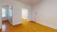 Located along Hennepin Avenue in Minneapolis, MN, this single-floor, 3-bedroom, 1-bathroom unit offers a practical and straightforward layout. Warm-toned hardwood floors run throughout the living areas and all three bedrooms, lending a consistent and classic character to the space. Each bedroom is bright and simply appointed, with natural light entering through white-framed windows fitted with blinds, and baseboard heating units ensuring year-round comfort. The primary bedroom is the most spacious of the three, offering ample room for furnishings, and features a ceiling fan with a light fixture. The two additional bedrooms are more compact but equally well-lit and functional. The kitchen is efficiently laid out with warm wood cabinetry, laminate countertops, a gas range, and tile flooring. A window above the counter brings in natural light and ventilation. The bathroom is clean and utilitarian, featuring a pedestal sink, toilet, tiled shower surround, tile flooring, and a window for natural light. Wall-mounted storage cabinets add functional storage. Throughout the unit, crisp white walls and trim create a neutral palette, while baseboard heating provides consistent warmth across all rooms.