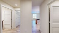 This thoughtfully designed 1-bedroom, 2-bathroom residence in Ellicott City, Maryland offers a clean, modern aesthetic throughout its efficiently utilized single-floor layout. Light wood-look flooring flows through the main living areas, complemented by crisp white walls and recessed lighting that create a bright, welcoming ambiance.

The kitchen is the standout feature of the home, showcasing warm wood cabinetry, a subway tile backsplash, and a granite-topped island with an integrated sink and dishwasher. A trio of sleek pendant lights hangs above the island, while stainless steel appliances — including a refrigerator, range, and microwave — complete the space. Natural light from a nearby window enhances the open connection between the kitchen and living area.

The bedroom offers a comfortable, carpeted retreat with a large window that fills the room with natural light. It includes access to a walk-in closet outfitted with wire shelving for organized storage. Two full bathrooms serve the home, one featuring a tiled tub-shower combo, wood-toned vanity, and white countertop.

A dedicated laundry room with full-size washer and dryer adds everyday convenience, and a hallway connects all areas of the home seamlessly. The overall design is clean, functional, and move-in ready.