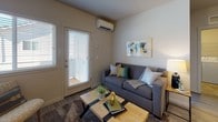 This single-floor residence offers a well-organized layout that balances functionality with comfort throughout its multiple rooms. The living area serves as a welcoming central space, featuring a wall-mounted mini-split climate control unit, neutral-toned walls, and a glazed exterior door that floods the room with natural light while providing direct access to an outdoor area. Durable flooring and a cozy area rug complete the relaxed atmosphere.

The galley-style kitchen is efficiently designed with dark cabinetry lining both walls, granite-look countertops, light wood-look flooring, and stainless steel appliances including a refrigerator and range. It offers ample storage and a practical workspace for everyday cooking.

Multiple bedrooms are carpeted and bright, each benefiting from large, blind-fitted windows that allow generous natural light and neighborhood views. The rooms are well-proportioned, accommodating full or queen-sized furniture comfortably.

Two bathrooms serve the unit: one features tile flooring, a dark wood vanity with a large mirror, and recessed lighting, while the second includes a tub-shower combination, tile flooring, and a small window for ventilation.

A dedicated laundry area houses a full-sized washer and dryer with overhead wire shelving for added storage. Overall, the space presents a clean, contemporary aesthetic with practical amenities throughout.