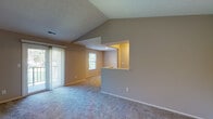 Located at 239 Sail Boat Run in Dayton, Ohio, this single-floor home combines thoughtful design with comfortable living. The open living area immediately impresses with its dramatic vaulted ceilings and a textured ceiling finish, creating an airy, expansive atmosphere. Plush carpeting runs throughout the main living spaces and bedrooms, adding warmth underfoot. A sliding glass door leads to a private balcony, allowing natural light to pour in and offering a pleasant outdoor retreat.

The kitchen is efficiently designed in a galley layout, featuring white cabinetry, dark granite-style countertops, stainless steel appliances including an electric range and a full-size refrigerator, and durable hardwood-style flooring. A pass-through window connects the kitchen to the living area, enhancing the sense of openness and flow between spaces.

The bedrooms are well-proportioned, each featuring soft carpeting, neutral wall tones, and windows that frame views of the surrounding greenery, filling the rooms with natural light. The bathroom is clean and functional, showcasing a white vanity with ample cabinet storage, a light countertop, hardwood-style flooring, and a towel bar for convenience. Overall, the home presents a neutral, move-in ready palette well-suited for a variety of living styles.