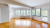Unit 631 at 3900 16th St NW offers a thoughtfully laid-out two-bedroom, two-bathroom residence on a single floor in Washington, DC's 16th Street Heights neighborhood. Warm parquet hardwood flooring flows consistently throughout the living areas and bedrooms, lending a classic character to the space.

The living room is generously proportioned, featuring large multi-pane windows along two walls that frame lush, tree-lined views and fill the room with abundant natural light. A radiator heating unit sits beneath the windows, adding a functional architectural element. The open sightline to the kitchen enhances the overall sense of space.

The kitchen is equipped with white cabinetry, granite-patterned countertops, a gas range, and tile flooring, with a window providing additional natural light and garden views.

The spacious primary bedroom includes a window with outdoor views, a closet, and parquet flooring. The second bedroom is well-sized and similarly finished. Both bathrooms feature clean, classic white fixtures — one with a tiled tub-shower surround, the other with a pedestal sink, mosaic tile flooring, and wall-mounted lighting. A hallway connects all rooms, completing this well-organized floor plan.