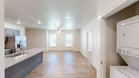 Located at 130 N Cedar St in Centerton, Arkansas, this single-story, one-bedroom, one-bathroom home offers a clean, modern design throughout. Light-toned wood-look flooring runs seamlessly across the entire space, complementing the crisp white walls and recessed lighting that brighten every room.

The open-concept kitchen and living area serves as the heart of the home. The kitchen is outfitted with gray shaker-style cabinetry, granite countertops, stainless steel appliances including a refrigerator, range, and microwave, and a large island with a built-in sink — ideal for both cooking and casual dining. The living area flows naturally from the kitchen, featuring a ceiling fan and multiple windows that invite abundant natural light.

The bedroom is a comfortable, well-lit retreat with a window overlooking the outdoors and direct access to a spacious walk-in closet equipped with multi-level hanging rods and shelving. The full bathroom features gray cabinetry with granite countertops, an undermount sink, an overhead storage cabinet, and a full tub-shower combination. Additional practical spaces include a dedicated pantry and an in-unit laundry room, rounding out this efficiently designed and move-in-ready home.