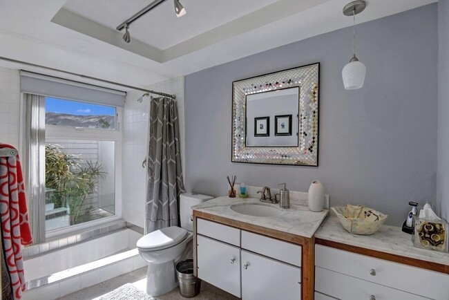 Master Bath with sunken tub, privacy wall in the exterior past the garden. - 2522 S Sierra Madre