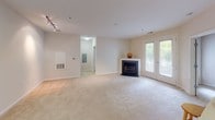 Located at 1620 E Jefferson St in Rockville, MD, this single-floor residence offers a thoughtfully designed layout with a clean, contemporary aesthetic throughout. The kitchen is a standout feature, equipped with stainless steel appliances including a gas range, over-the-range microwave, and a side-by-side refrigerator with an in-door water and ice dispenser. Rich walnut-toned cabinetry extends from floor to ceiling, complemented by light quartz countertops and a decorative mosaic tile backsplash in earth tones. Light porcelain tile flooring completes the kitchen's polished look. The open living area flows seamlessly from the kitchen, highlighted by plush neutral carpeting, track lighting, and a classic fireplace flanked by French doors that invite natural light and outdoor views. The primary bathroom features a dual-sink vanity with walnut cabinetry, backlit mirrors, mosaic tile accent walls, and a full soaking tub-shower combination. A second bathroom mirrors this refined tile detailing with a tub-shower combo. The bedrooms are generously sized, carpeted, and filled with natural light from multiple windows, with at least one bedroom offering double-door closet storage. The overall ambiance is calm, neutral, and move-in ready.