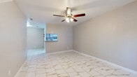 Located at 8323 Cinnamon Ln in Houston, TX, this two-story home offers a well-organized layout spread across two floors. The main level features a bright living and dining area adorned with polished marble-style tile flooring and a ceiling fan, creating a clean and airy atmosphere. A staircase runs along one wall, adding architectural character to the space. The kitchen is designed in a galley style, equipped with white appliances, granite-style countertops, a tiled backsplash, and ample cabinetry, with a pass-through counter connecting it to the dining area. The upper floor is home to the spacious primary bedroom, which is carpeted and bathed in natural light from a window with outdoor views of greenery. A ceiling fan adds comfort to the room, and closet space is conveniently accessible. The upper level also includes a fireplace-equipped sitting area with soft carpeting, ideal for relaxing. Both bathrooms are finished with marble-style tile flooring and walls, granite-accented vanities, and tub-shower combinations. With multiple closets throughout, the home provides generous storage. Ceiling fans are present in the key living areas, contributing to comfortable year-round living in the Houston climate.