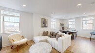 Located in Philadelphia's desirable Rittenhouse Square neighborhood, this well-appointed one-bedroom, one-bathroom residence offers a thoughtfully designed single-floor layout. Light wood flooring and a crisp white palette flow consistently throughout, creating a bright, cohesive aesthetic.

The open-concept living and dining area is the heart of the home, bathed in natural light from multiple windows framing city skyline views. The living space accommodates comfortable seating alongside a defined dining area, making it ideal for both relaxing and entertaining.

The kitchen is outfitted with full-height white cabinetry, dark countertops, a classic white subway tile backsplash, and a complete suite of stainless steel appliances including a range, built-in microwave, dishwasher, and side-by-side refrigerator, all complemented by a professional-style ventilation hood.

The bedroom features a large built-in sliding-door closet and connects seamlessly to the rest of the unit via the hallway. The bathroom offers a standout glass-enclosed walk-in shower finished in floor-to-ceiling marble-look tile with built-in shelving.

The entry hallway includes a louvered interior door and a built-in bench, providing a refined transition into the main living space.
