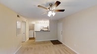 Located at 222 Old Fayetteville Rd in Carrboro, North Carolina, this single-floor residence offers a practical and well-appointed layout designed for comfortable everyday living. The open-concept living area is finished with light-toned flooring and neutral wall colors, creating a bright and welcoming atmosphere. A ceiling fan with an integrated light fixture serves as both a functional and decorative centerpiece overhead.

The kitchen is seamlessly integrated into the living space via a peninsula-style breakfast bar with a dark countertop, providing an ideal spot for casual dining or entertaining. The kitchen itself is equipped with white cabinetry, a stainless steel refrigerator, an electric range, and track lighting overhead, offering a clean and efficient cooking environment.

A dedicated in-unit laundry area is conveniently tucked just off the main living space, housing a full-size washer and dryer side by side — a practical feature that adds significant day-to-day convenience. The entry door is positioned to one side of the living area, offering a straightforward and accessible flow throughout the unit. Overall, the space combines a functional open layout with essential modern amenities in a clean, move-in ready condition.